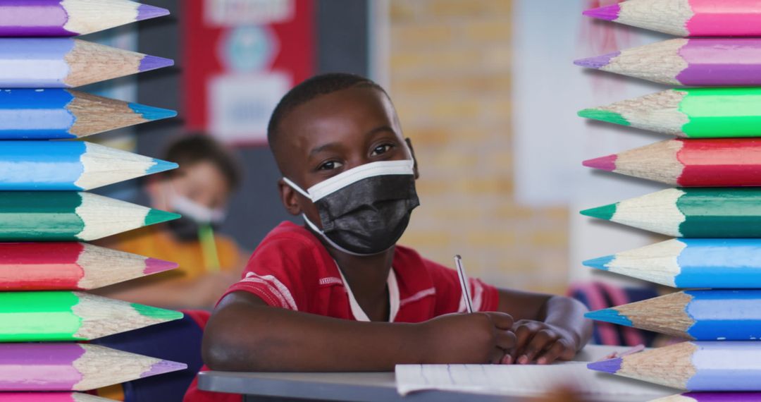 Student Masked and Focused, Framed by Colorful Pencils