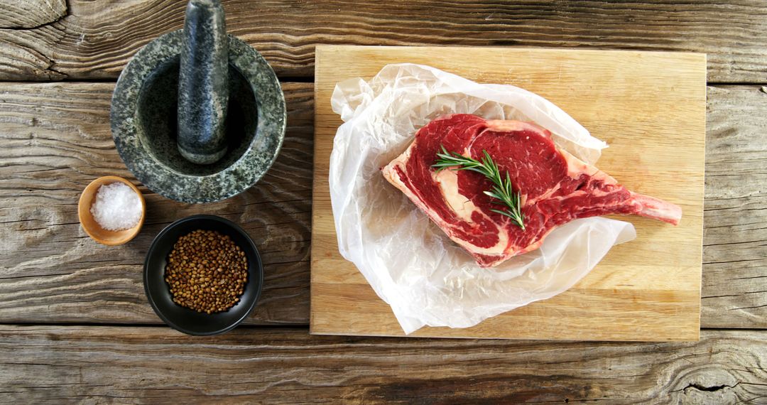 Raw Ribeye Steak with Rosemary on Wooden Cutting Board - Free Images, Stock Photos and Pictures on Pikwizard.com