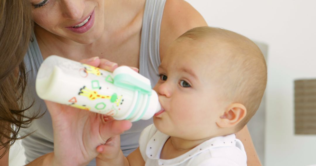 Mother Feeding Baby with Bottle in Home Setting - Free Images, Stock Photos and Pictures on Pikwizard.com