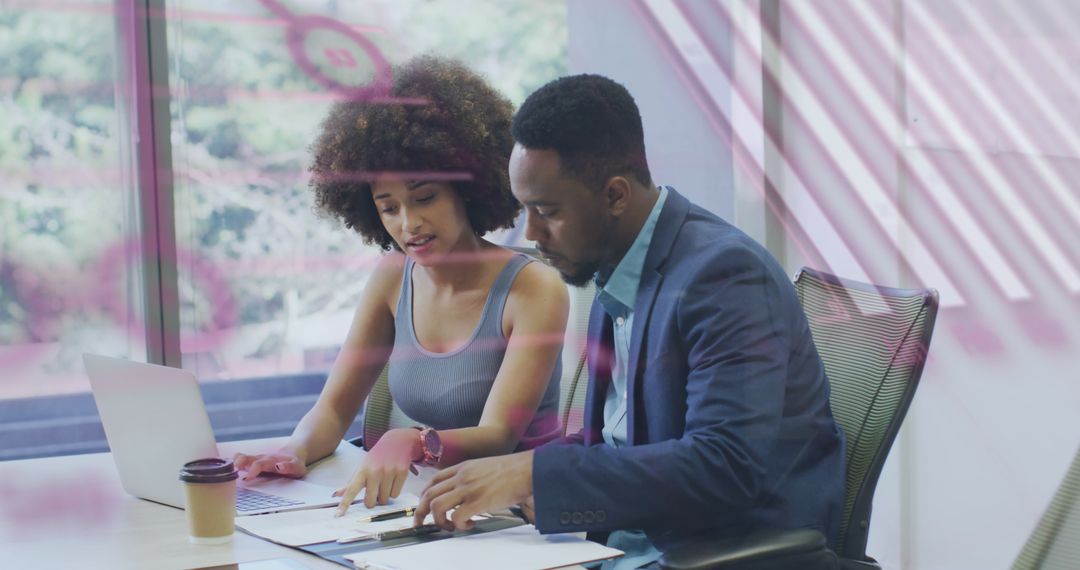 Two Colleagues Collaborate While Reviewing Data in Modern Office
