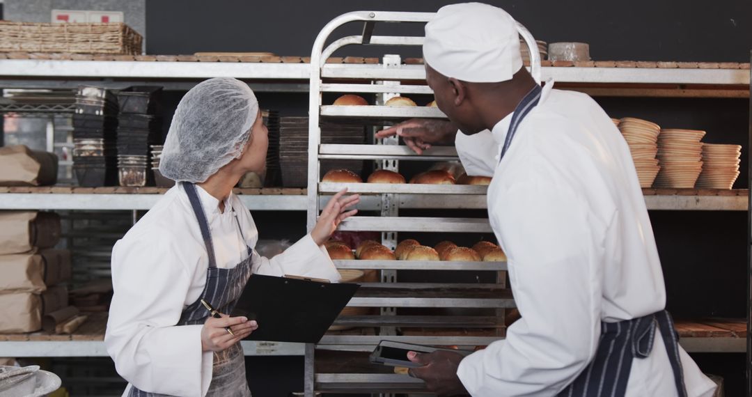 Team of Bakers Inspecting Freshly Baked Bread in Industrial Kitchen - Free Images, Stock Photos and Pictures on Pikwizard.com