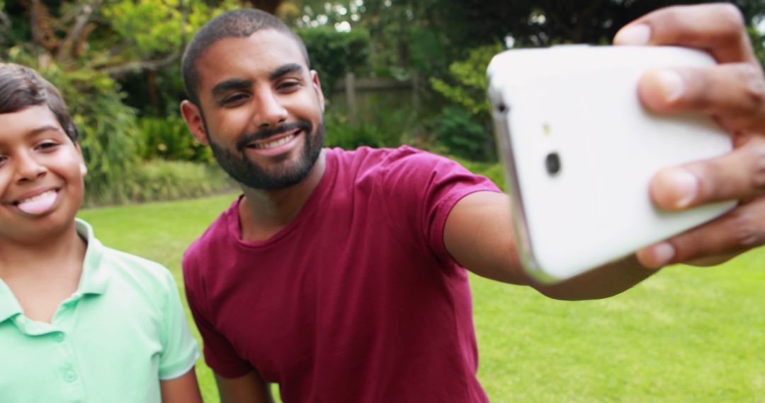 Cheerful Father and Son Taking Selfie in Green Garden - Free Images, Stock Photos and Pictures on Pikwizard.com