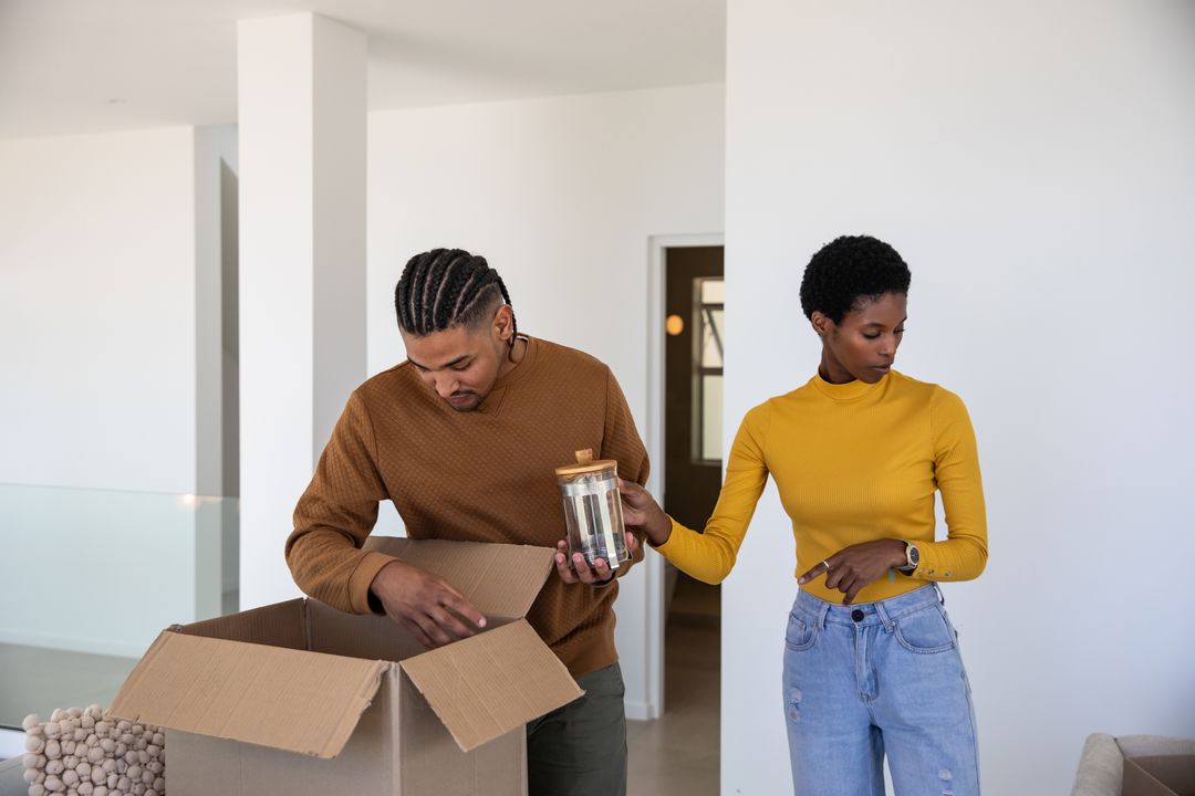 Diverse Couple Organizing New Home Unpacking Cardboard Box