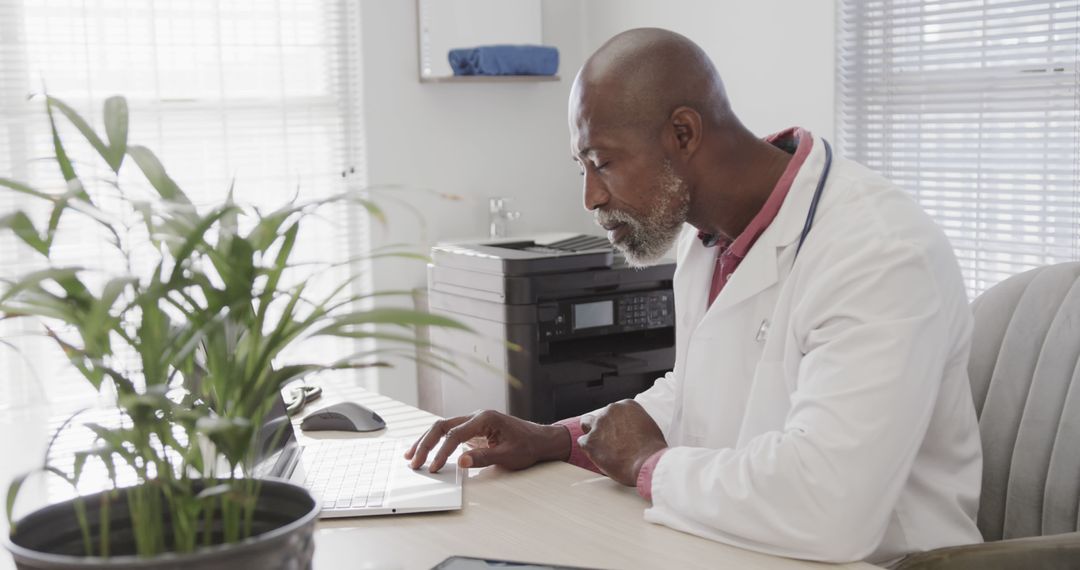 Focused African American Doctor Typing Medical Records in Office - Free Images, Stock Photos and Pictures on Pikwizard.com