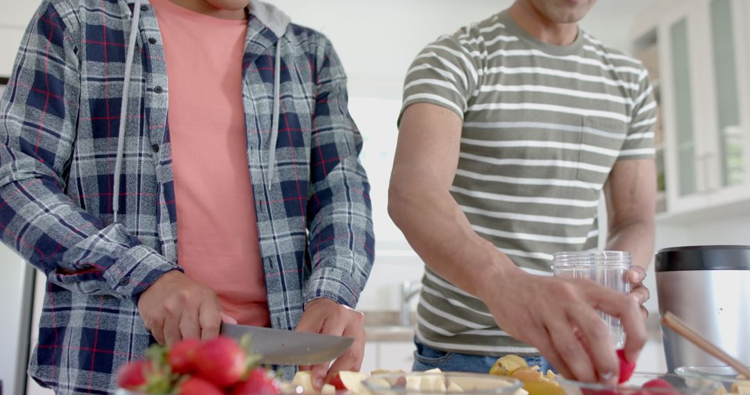 Diverse Male Couple Preparing Healthy Fruit Smoothie in Kitchen
