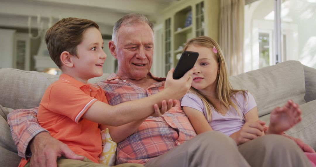 Grandfather and Grandchildren Using Smartphone on Couch - Free Images, Stock Photos and Pictures on Pikwizard.com