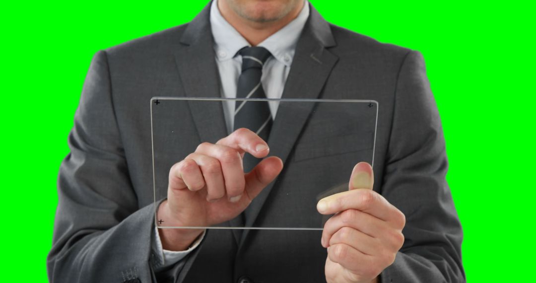 Businessman Using Futuristic Transparent Digital Tablet on Green Screen - Free Images, Stock Photos and Pictures on Pikwizard.com