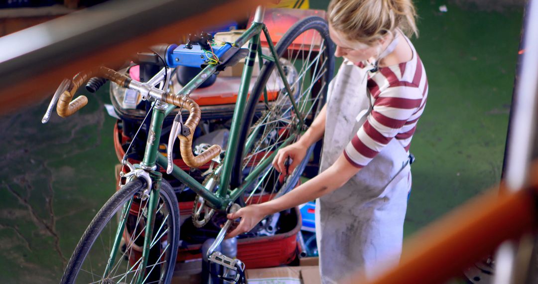 Young Woman Expertly Repairing Bicycle in Bicycle Workshop - Free Images, Stock Photos and Pictures on Pikwizard.com