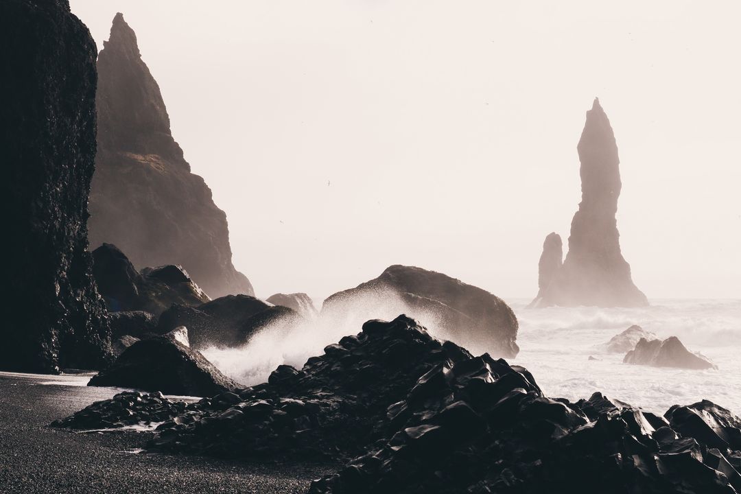 Moody Waves Crashing on Black Volcanic Beach with Jagged Sea Stacks and Mist