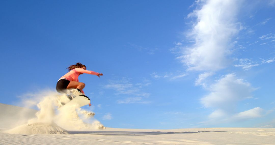 Energetic Woman Leaping on Sandy Dune under Clear Blue Sky - Free Images, Stock Photos and Pictures on Pikwizard.com