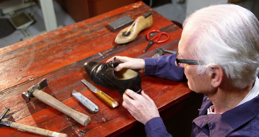 Senior Cobbler Repairing Leather Shoe on Workbench - Free Images, Stock Photos and Pictures on Pikwizard.com