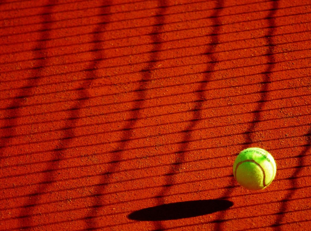 Tennis Ball on Red Court with Shadow from Net - Free Images, Stock Photos and Pictures on Pikwizard.com