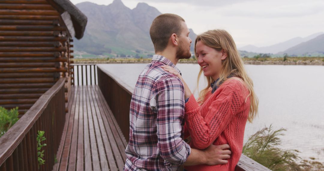 Caucasian Couple Embracing on Scenic Mountain Cabin Deck