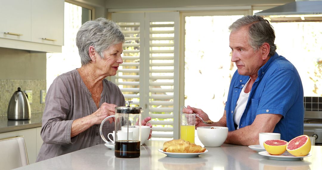 Senior Couple Enjoying Breakfast Together at Home Kitchen - Free Images, Stock Photos and Pictures on Pikwizard.com