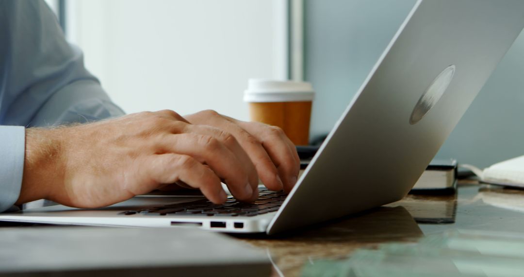 Businessman Typing on Laptop in Professional Office Environment