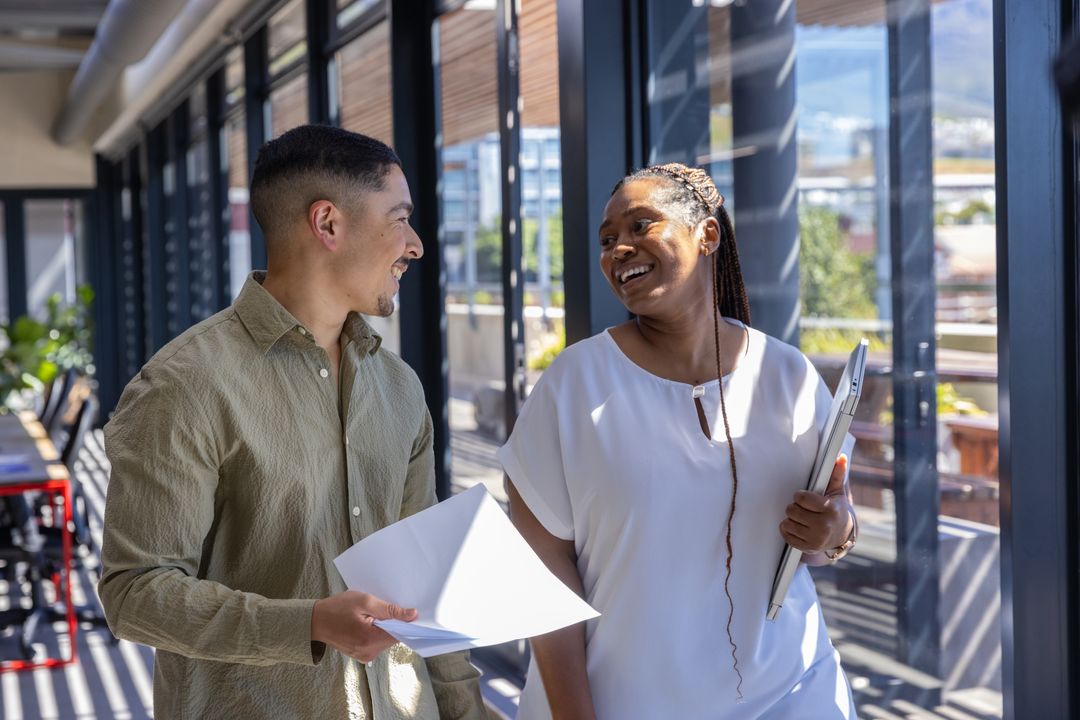 Diverse Coworkers Collaborating in Modern Office Corridor