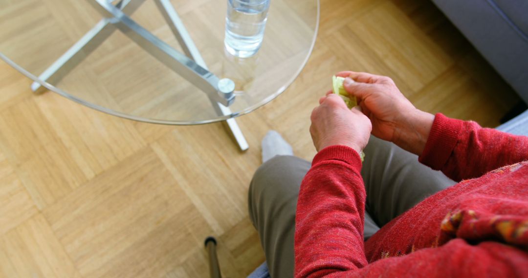 Senior Person Sitting Near a Glass of Water and Holding Pills in Hand - Free Images, Stock Photos and Pictures on Pikwizard.com