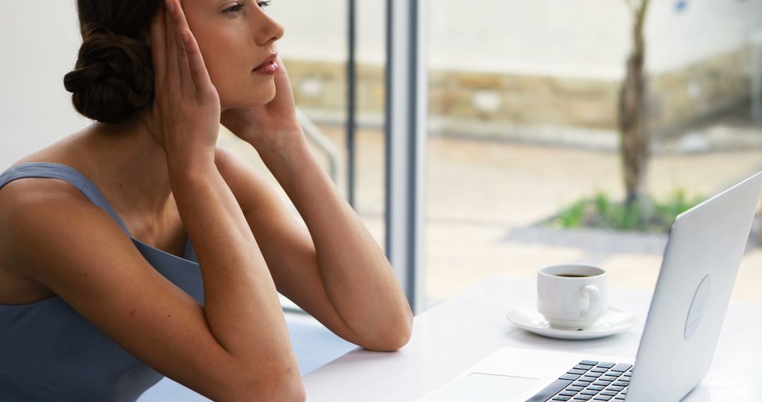 Stressed Businesswoman Holding Head near Laptop in Office - Free Images, Stock Photos and Pictures on Pikwizard.com