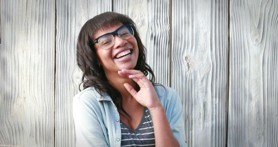 Happy Young Woman Smiling Against Wooden Background - Free Images, Stock Photos and Pictures on Pikwizard.com