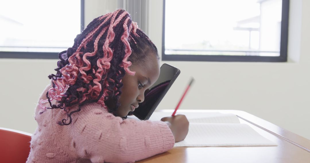 Young Student Studying with Tablet and Notebook at Desk