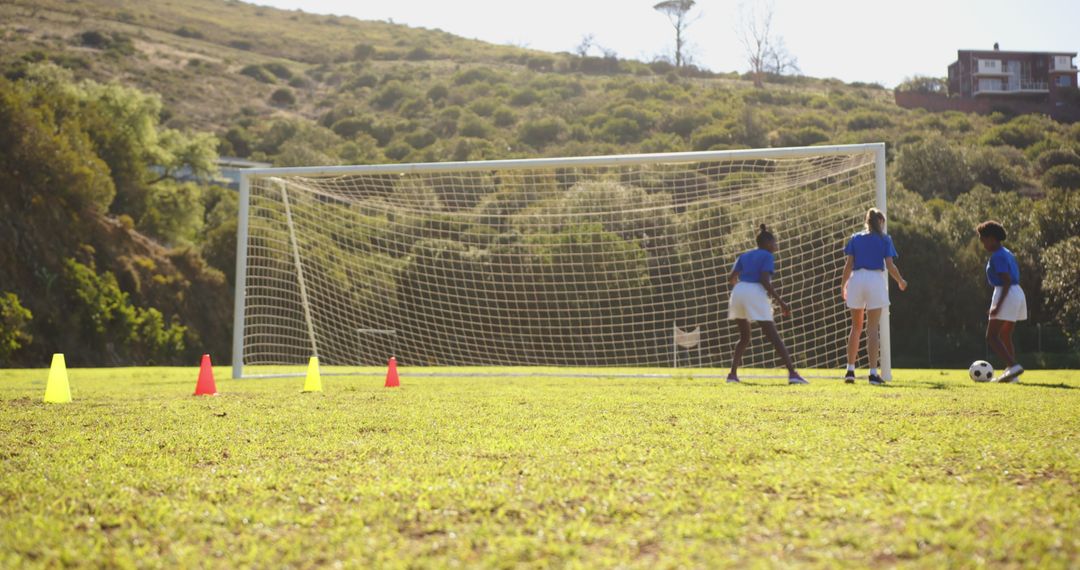 Girls Practicing Soccer on School Field with Goal Setting