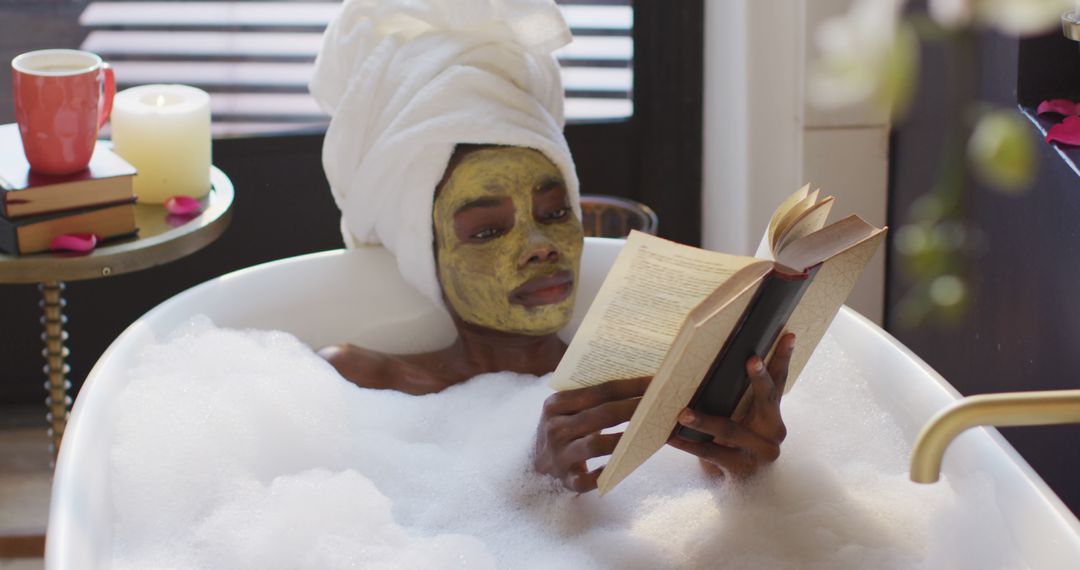 African american woman with towel and mask taking bath and reading book in bathroom - Free Images, Stock Photos and Pictures on Pikwizard.com