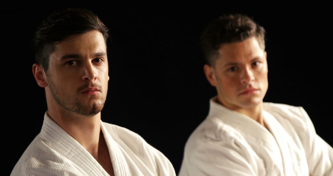 Two Male Martial Artists Posing in Karate Uniforms on Black Background - Free Images, Stock Photos and Pictures on Pikwizard.com