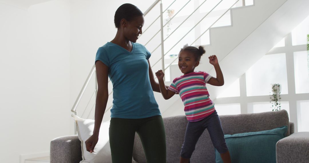 Active Mother and Daughter Dancing Together at Home - Free Images, Stock Photos and Pictures on Pikwizard.com