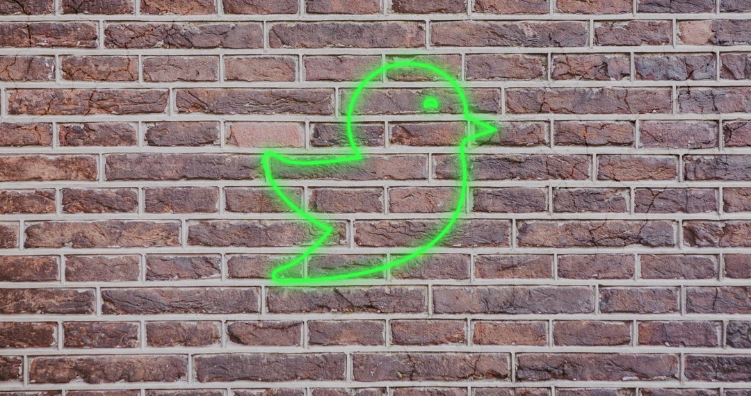 Green Glowing Bird Icon on Brick Wall, Twitter Representation - Free Images, Stock Photos and Pictures on Pikwizard.com