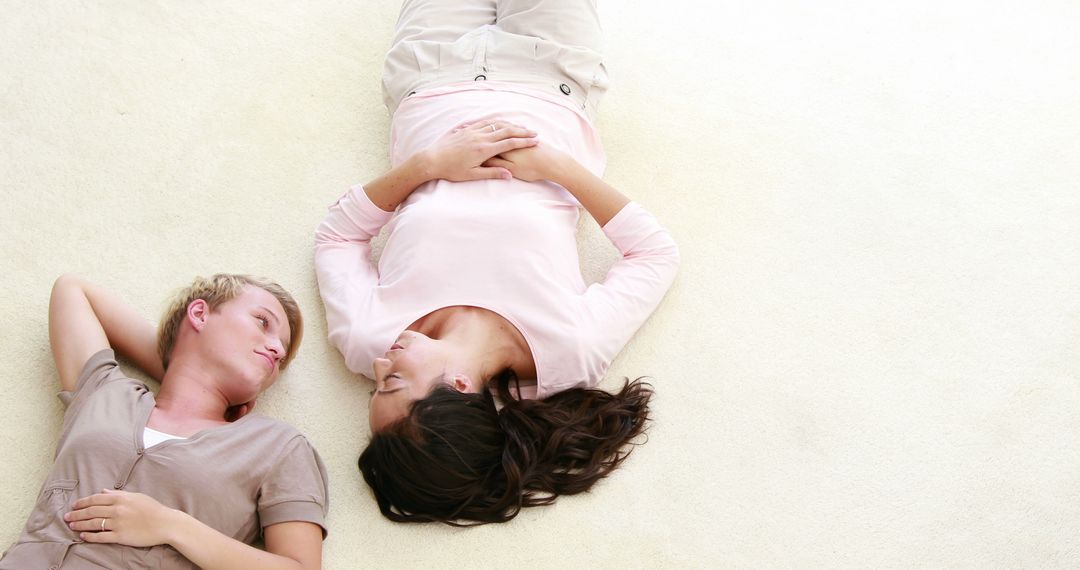 Two Friends Lying on Carpet and Smiling at Each Other - Free Images, Stock Photos and Pictures on Pikwizard.com