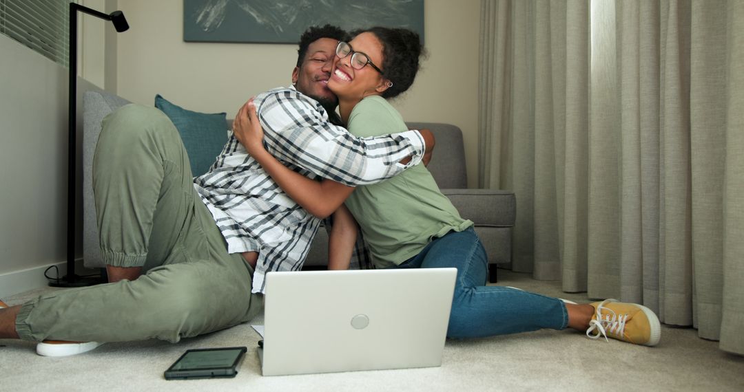 Couple Embracing and Collaborating with Laptop and Notebook in Cozy Living Room
