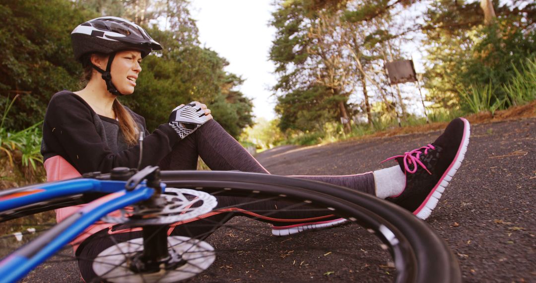 Injured Female Cyclist Sitting on Road After Accident - Free Images, Stock Photos and Pictures on Pikwizard.com