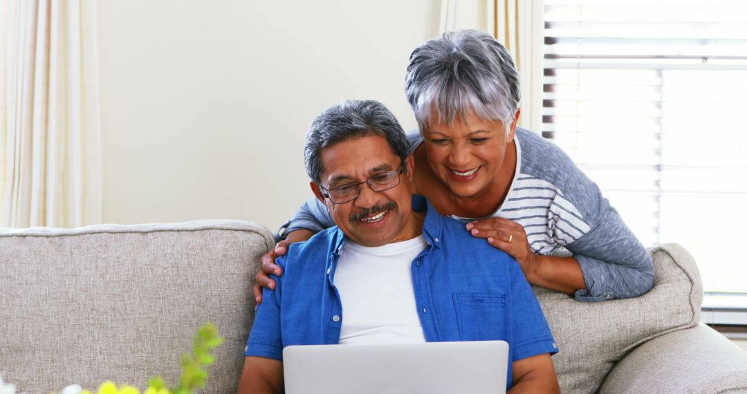 Senior Couple Enjoy Computing in Living Room