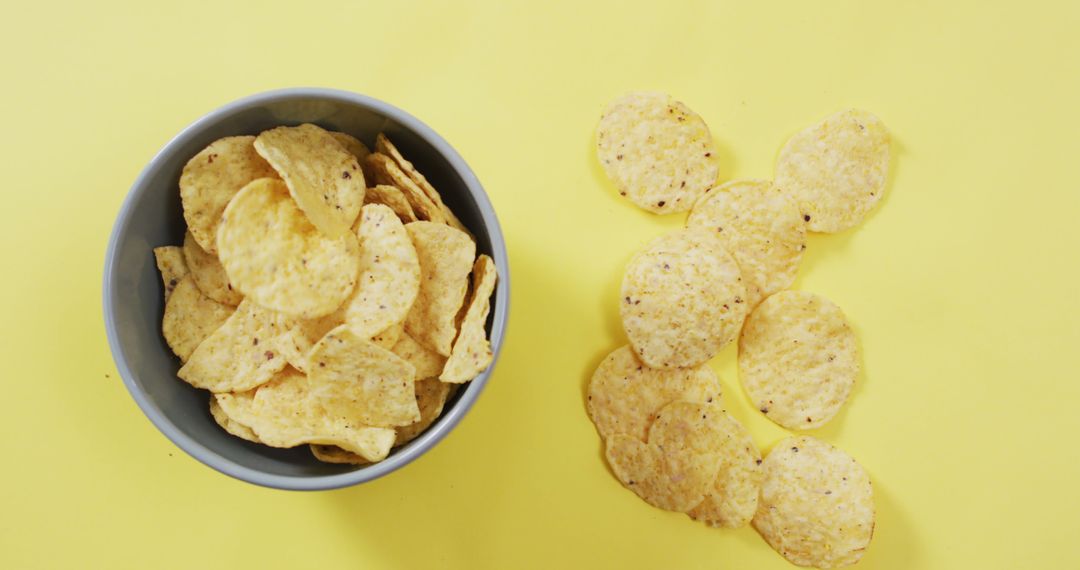 Close up of potato chips in a bowl on yellow surface - Free Images, Stock Photos and Pictures on Pikwizard.com