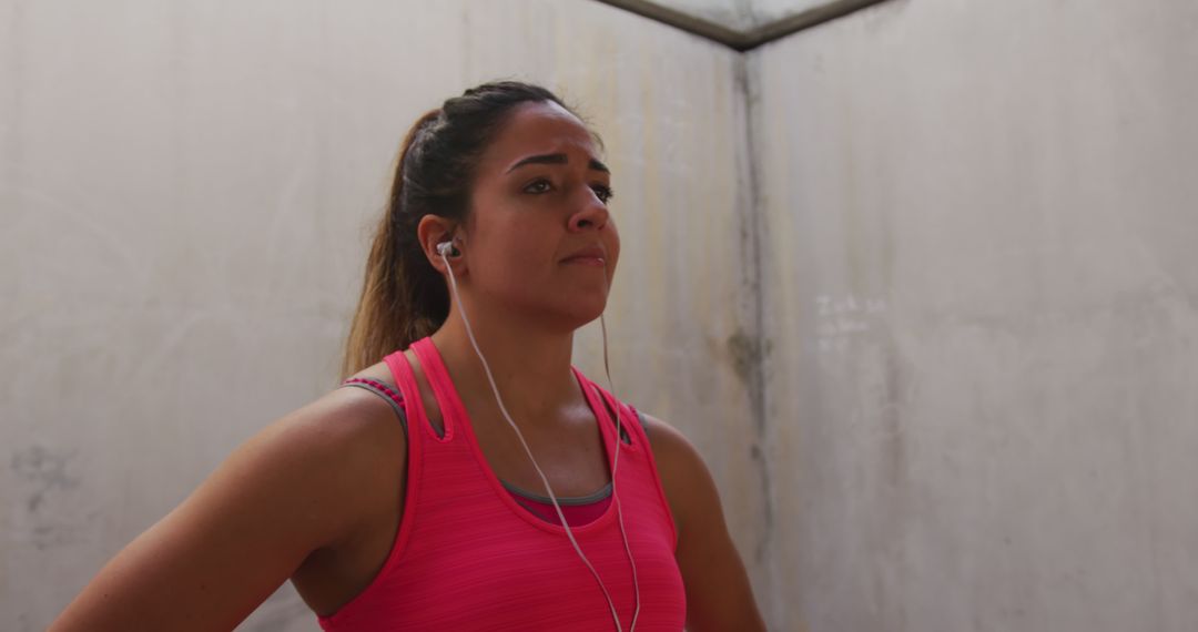 Motivated Young Woman Ready for Workout with Earphones in Urban Environment - Free Images, Stock Photos and Pictures on Pikwizard.com