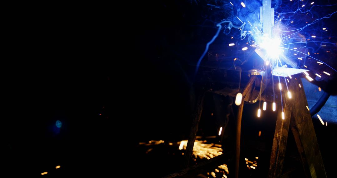 Welder Working with Heavy Sparks, Bright Light in Workshop Highlighting Industrial Metalwork - Free Images, Stock Photos and Pictures on Pikwizard.com