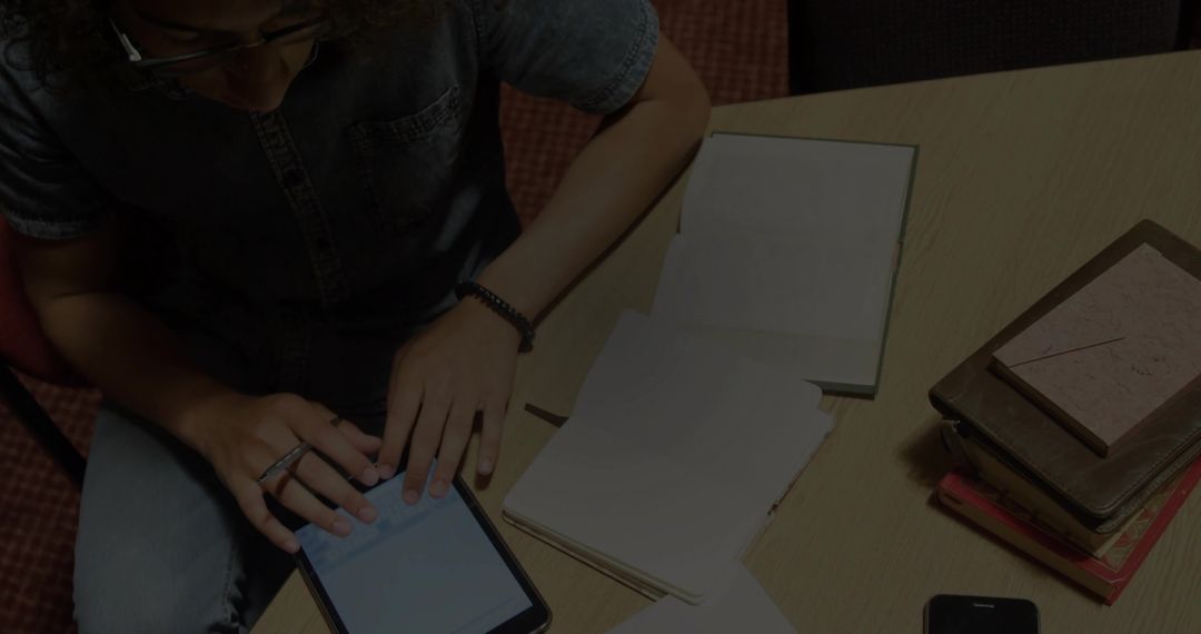 Student Using Tablet for Study in Casual Workspace Setting