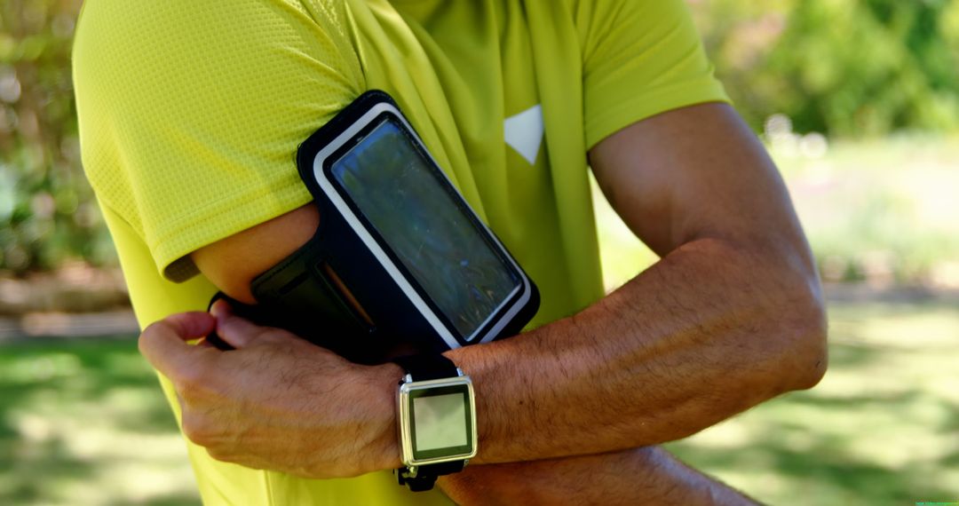 Man Adjusting Sport Armband and Smartwatch Outdoors - Free Images, Stock Photos and Pictures on Pikwizard.com