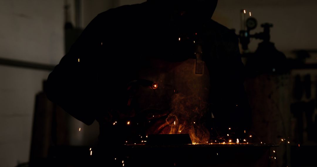 Silhouette of Metal Worker Welding in Dimly Lit Workshop - Free Images, Stock Photos and Pictures on Pikwizard.com