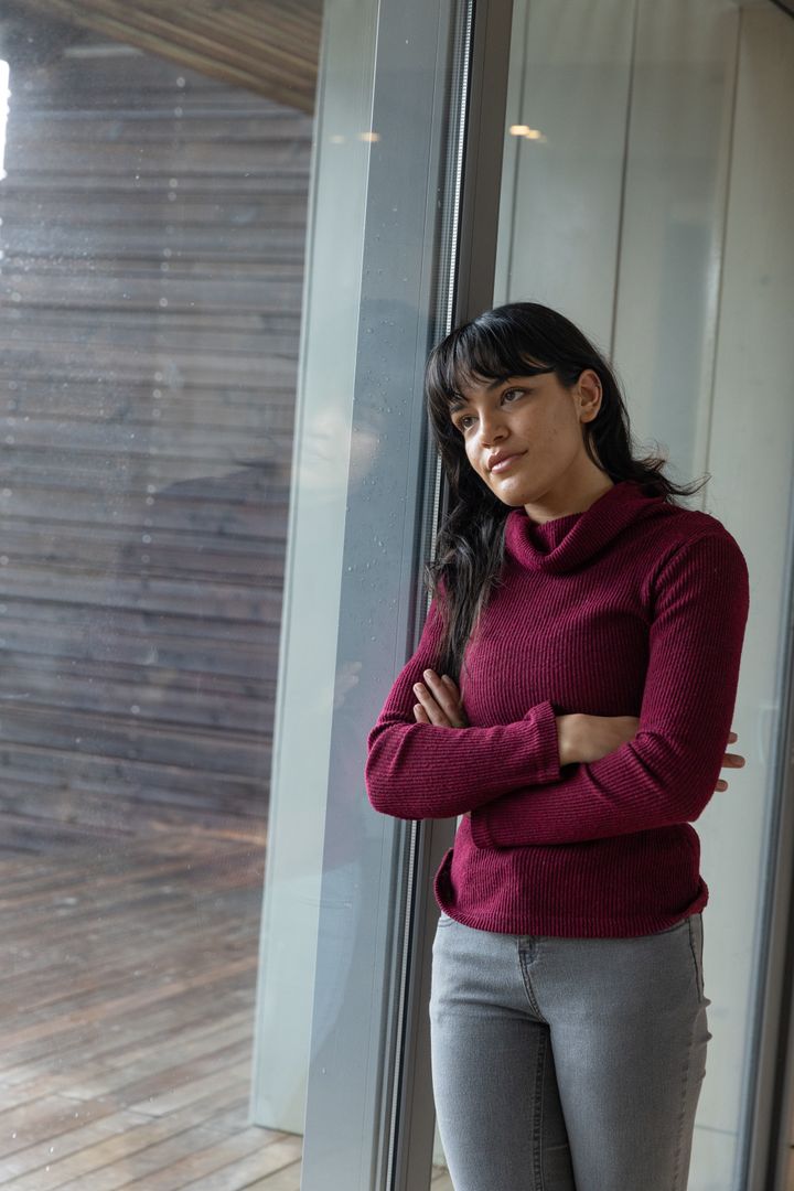 Woman Reflecting Through Window on Rainy Day With Contemplative Expression