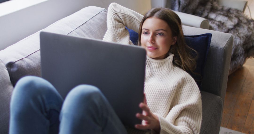 Woman Relaxing on Couch Using Laptop in Cozy Living Room - Free Images, Stock Photos and Pictures on Pikwizard.com