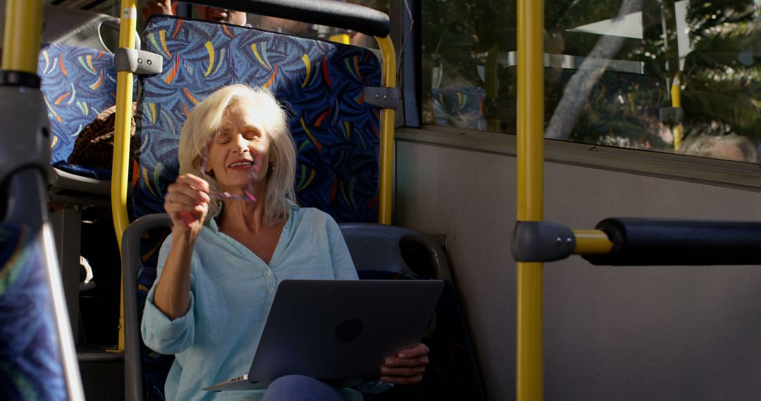 Smiling Senior Woman Using Laptop on Public Transport - Free Images, Stock Photos and Pictures on Pikwizard.com