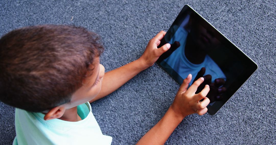 Child Engaging with Tablet Device on Carpet - Free Images, Stock Photos and Pictures on Pikwizard.com