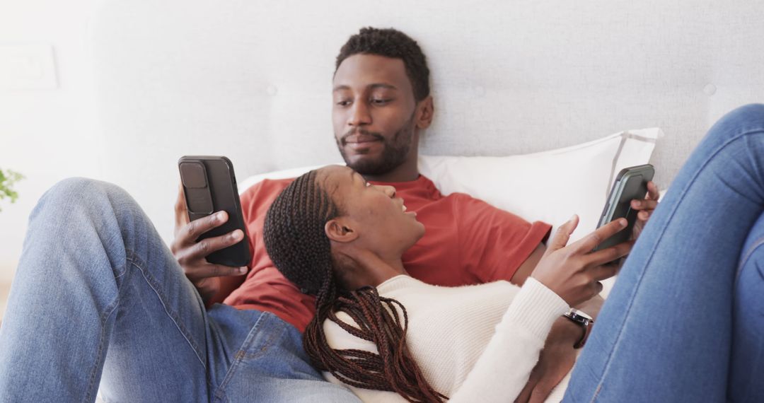 Couple Enjoying Relaxation Together While Using Smartphones in Bed