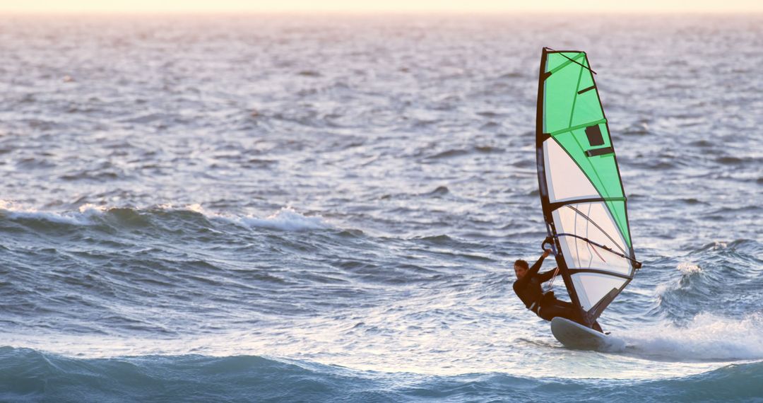 Caucasian Man Enjoying Windsurfing on Ocean at Sunset - Free Images, Stock Photos and Pictures on Pikwizard.com