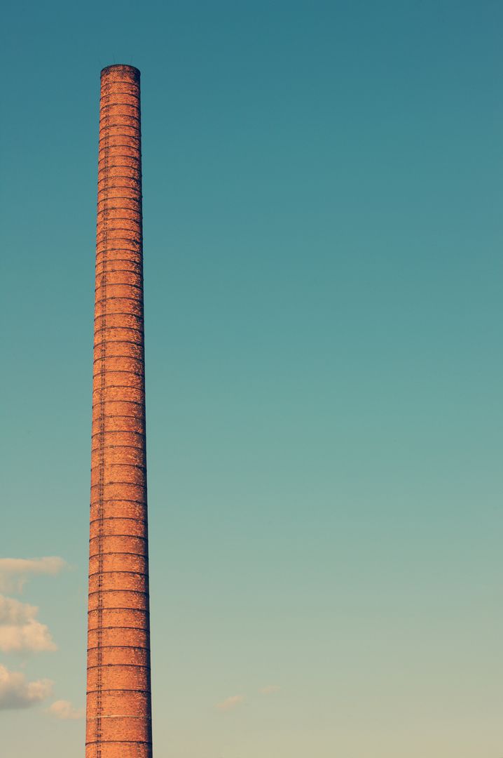 Tall Industrial Chimney against Clear Blue Sky - Free Images, Stock Photos and Pictures on Pikwizard.com