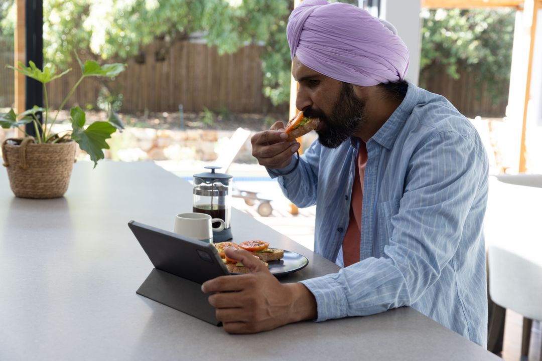 Man Enjoying Breakfast and Browsing Tablet in Cozy Kitchen