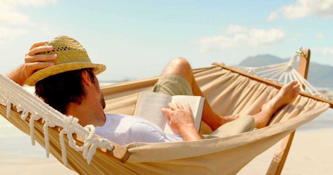 Man Relaxing on Beach Hammock Reading Book - Free Images, Stock Photos and Pictures on Pikwizard.com