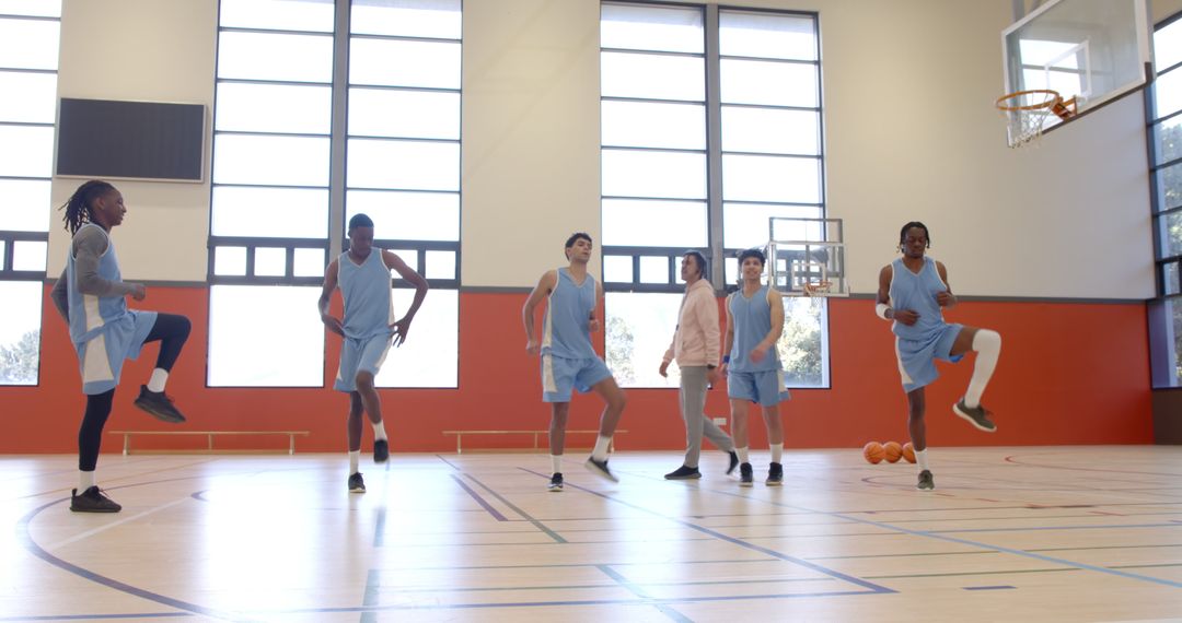 Diverse Basketball Team Practicing Warm-Up Drills in Gym