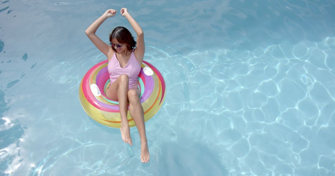 Joyful Woman Relaxing on Inflatable Pool Float in Crystal Clear Water